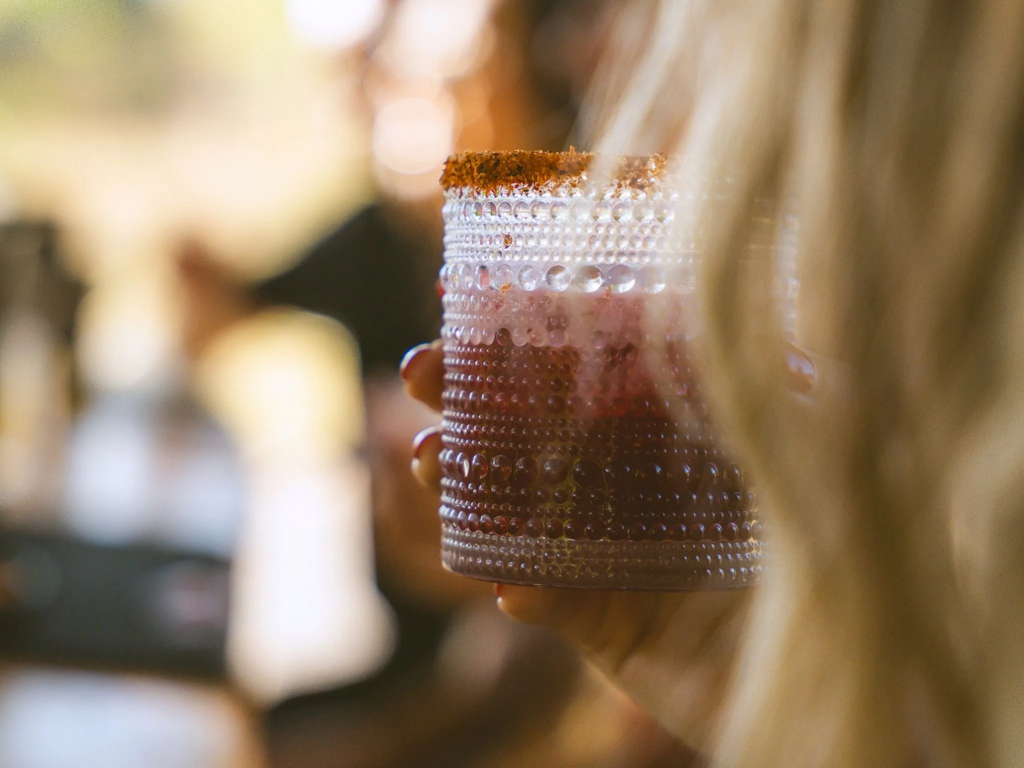 Hibiscus cocktail with a chile-salt rim held at the Cachashade Bar, Cachasol Farm Distillery