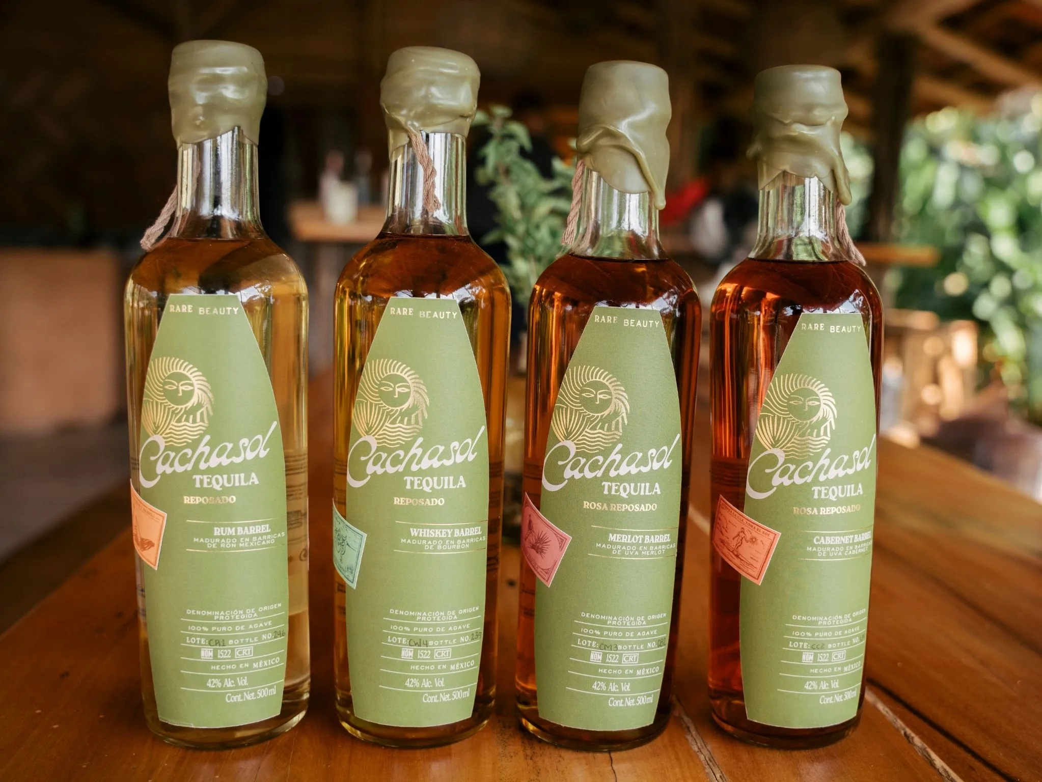 Four Cachasol Rare Beauty Reposado bottles on the bar: Rum, Whiskey, Merlot and Cabernet Barrel