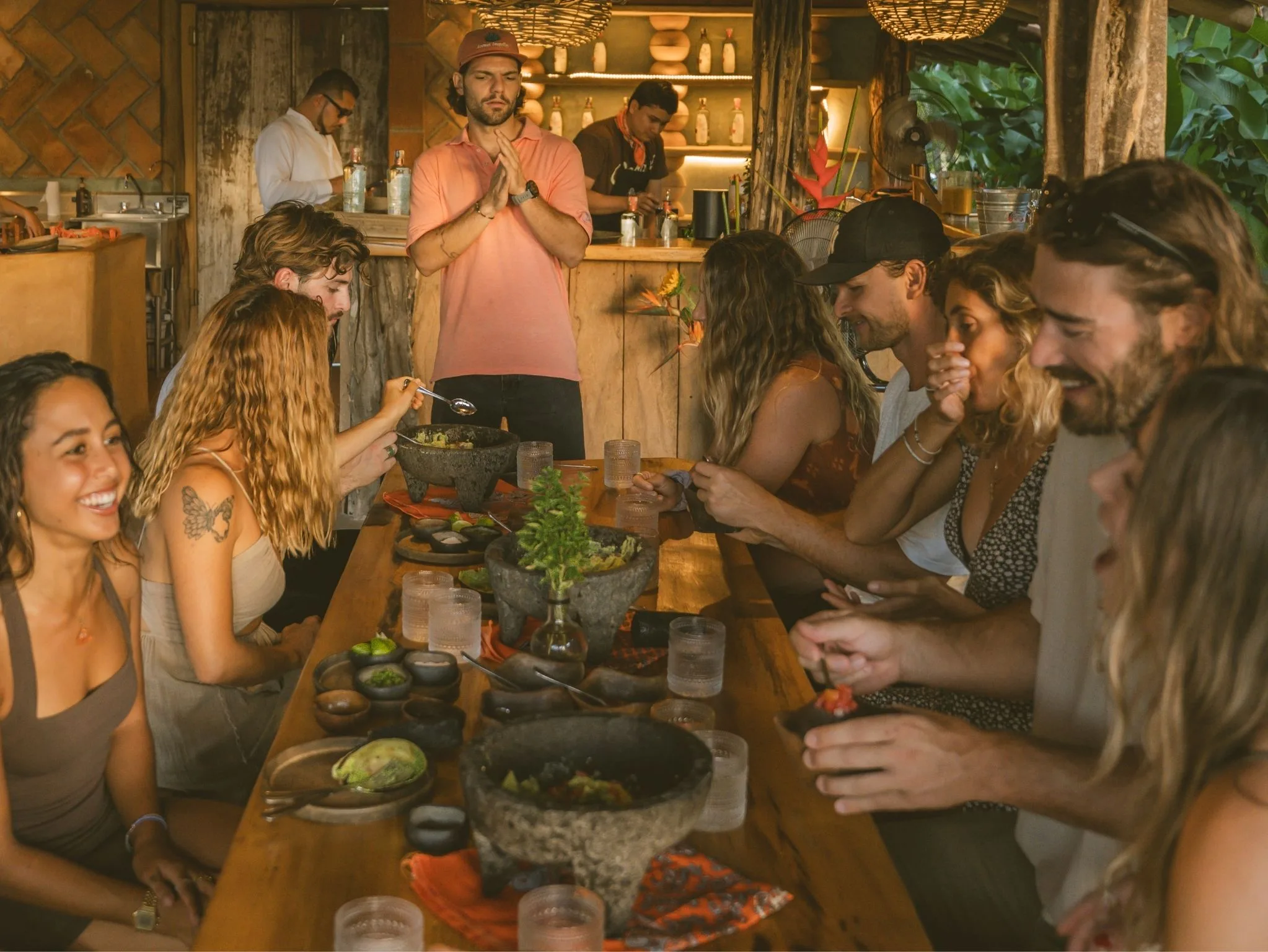 Guests sharing guacamole and cocktails at the long table in the comedor, Cachasol Farm Distillery