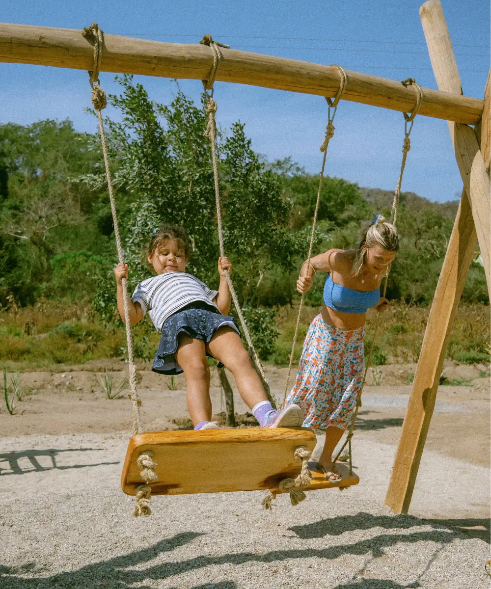 A child on the swing at the hand-built wooden playground, Cachasol Farm Distillery