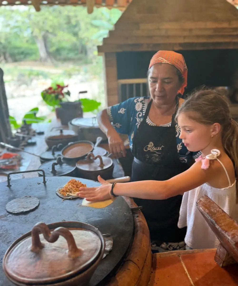 A young guest cooking at the comal with our cook, Cachasol Farm Distillery